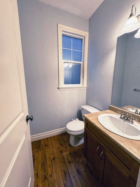 A bathroom with a toilet, sink, and window.