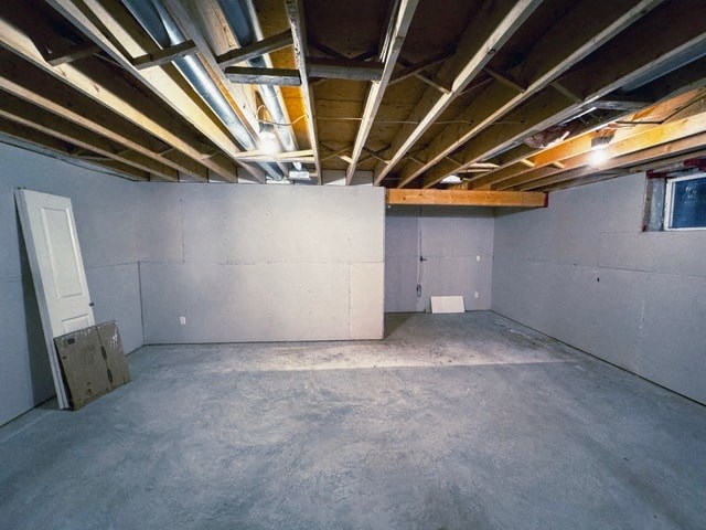 A room with a concrete floor and a ceiling with wooden beams.