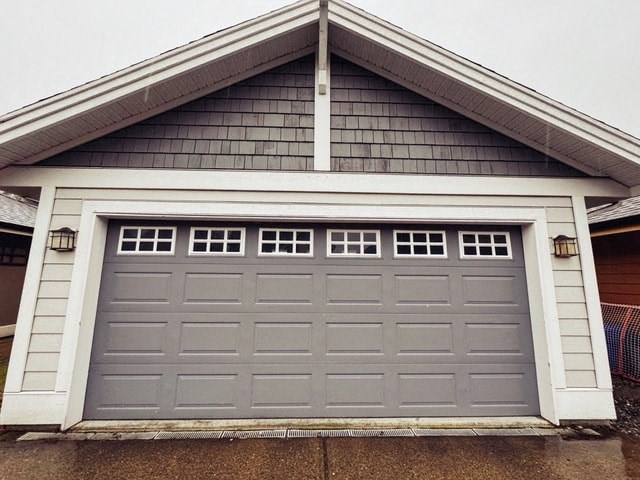 A grey garage door is closed and has a white frame.