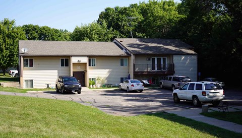 A house with a driveway and cars parked in front.
