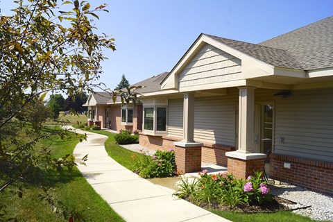 A row of houses with a sidewalk in front.