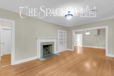 A room with a fireplace and a sign that says "The Space Co."