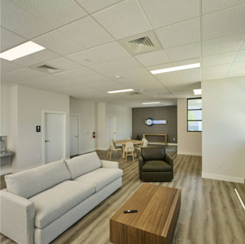 A white couch is in a room with a wooden coffee table.