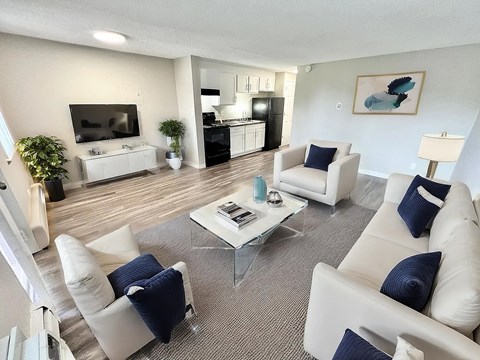 A living room with white furniture and a flat screen TV.