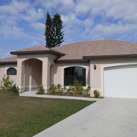 A house with a brown roof and a white garage door.