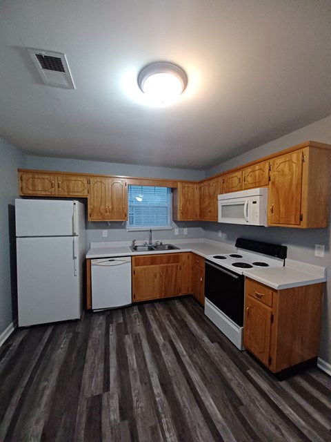 A kitchen with wooden cabinets and a white fridge.