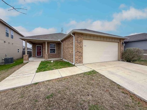 A house with a red door and a garage door.