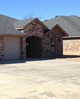 A house with a garage door and a driveway.