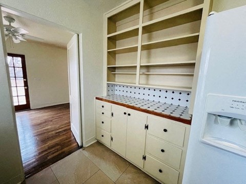 A kitchen with a white fridge and wooden cabinets.