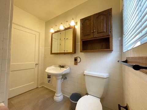 A white toilet sits next to a sink in a small bathroom.