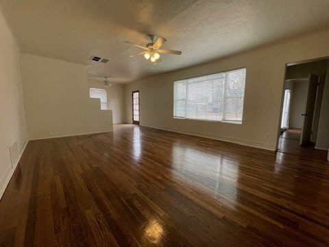 A room with wooden floors and a ceiling fan.