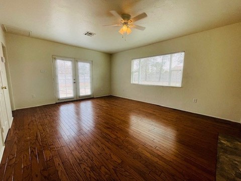 A room with wooden floors and a ceiling fan.