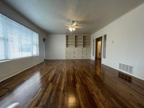A room with wooden floors and a ceiling fan.
