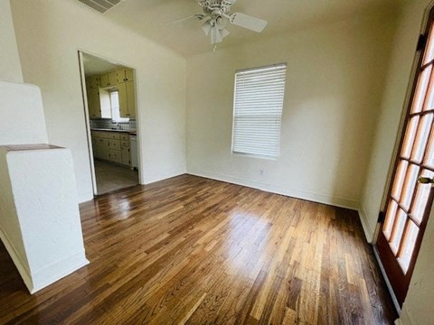 A room with wooden floors and a ceiling fan.