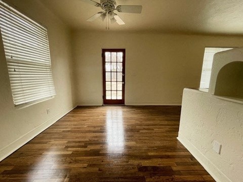 A room with wooden floors and a ceiling fan.