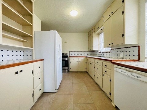 A kitchen with white appliances and cabinets.