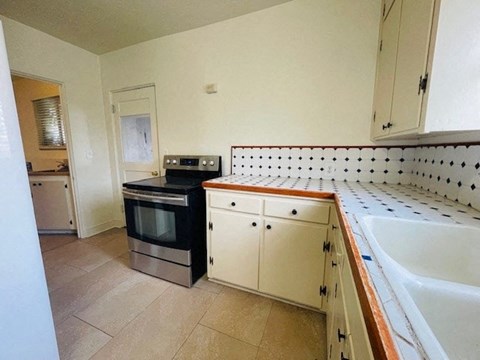 A kitchen with white cabinets and a black oven.