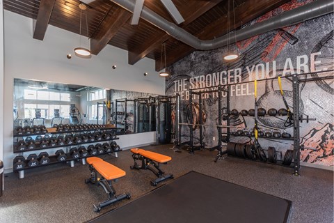 A gym with a wall mural that says "The stronger you are, the stronger you feel".