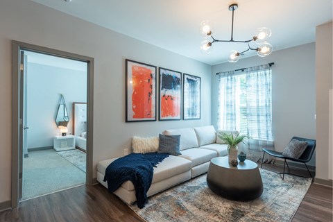 A living room with a white couch and a grey coffee table.