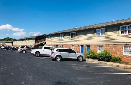 A parking lot with cars and a building in the background.