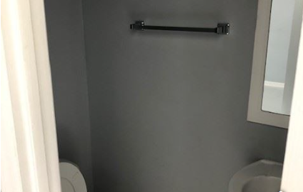 A white toilet paper roll is on the wall.