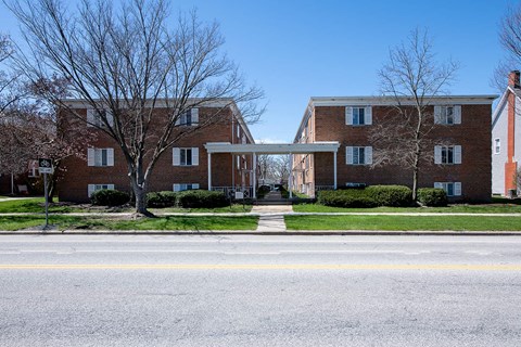 A large brick building with a white doorway connecting two wings.