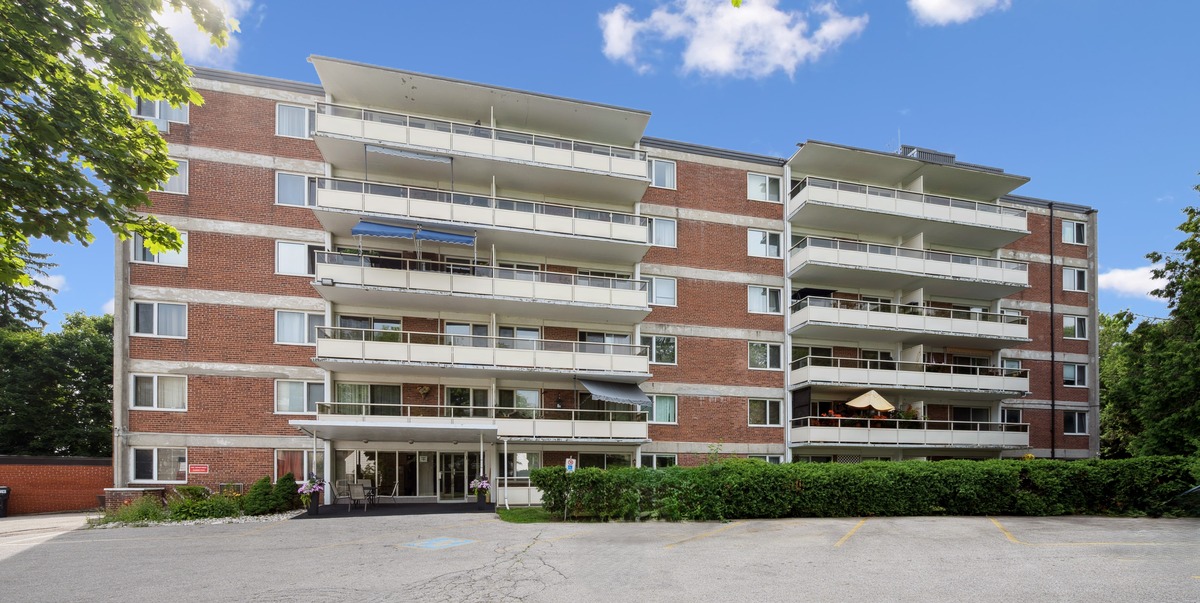A large red brick building with a parking lot in front.