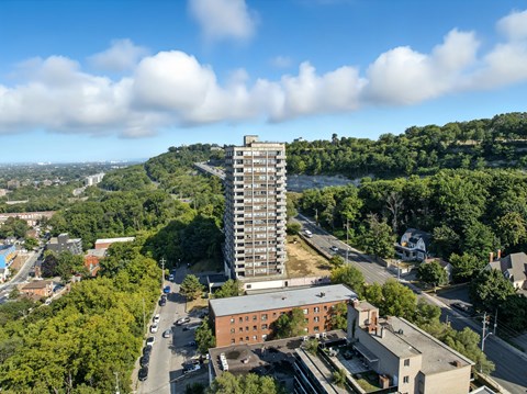 A tall building stands in the middle of a green landscape.