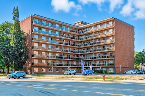 A large red brick apartment building with balconies and multiple windows.