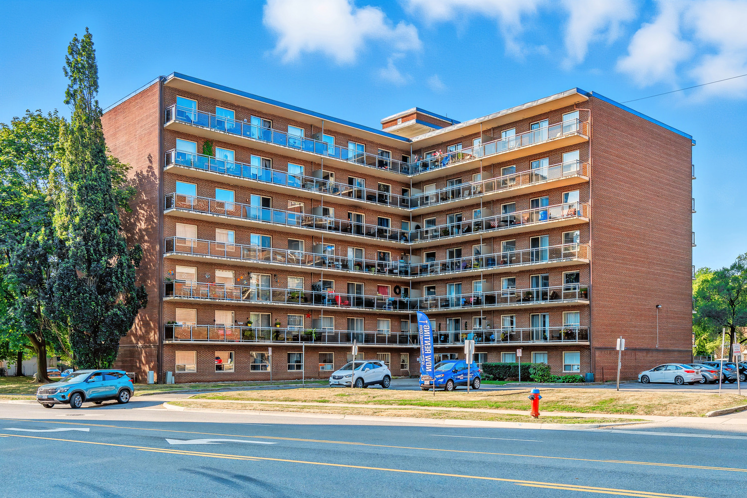 A large red brick apartment building with balconies and multiple windows.