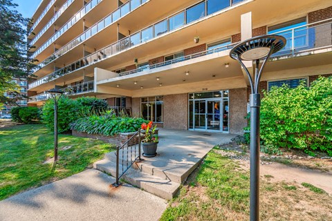 A building with a balcony and a tree in front of it.