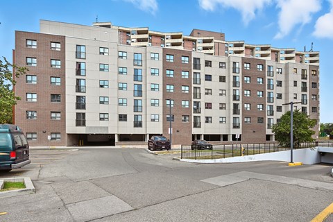 A large apartment building with a parking lot in front.