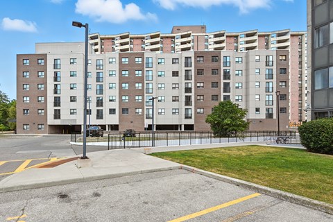 A large apartment building with a parking lot in front.