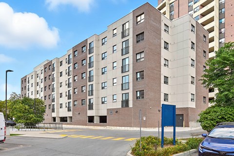 A large brick building with a blue sign in front.