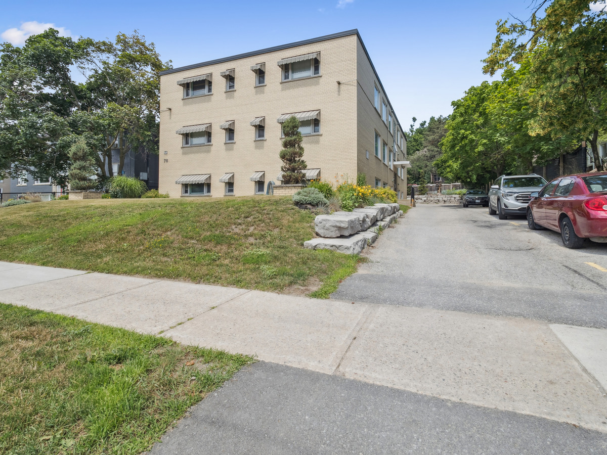 A beige building with a green lawn in front.