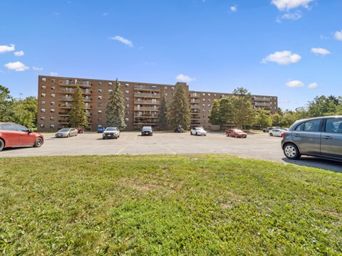 A parking lot with cars and apartment buildings in the background.