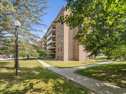 A tall building with a grassy area in front of it.