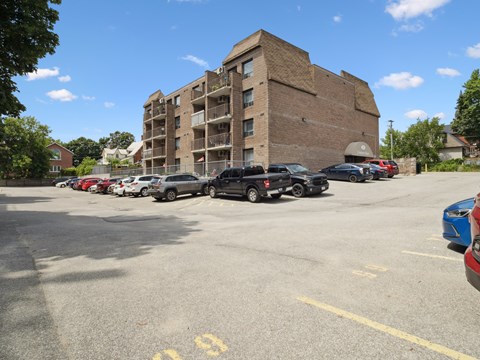 A parking lot with cars and a building in the background.