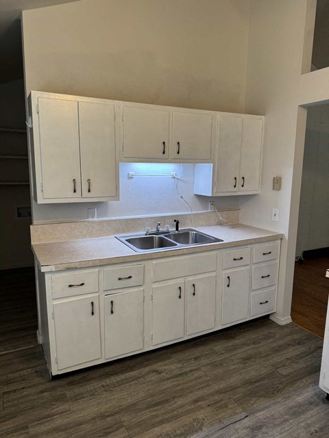 A kitchen with white cabinets and a sink.