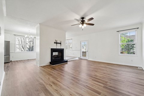 A spacious living room with a fireplace and hardwood floors.