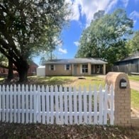 A white picket fence in front of a house.