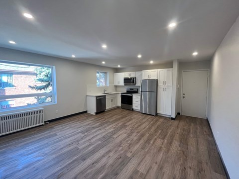 A spacious kitchen with white cabinets and a refrigerator.