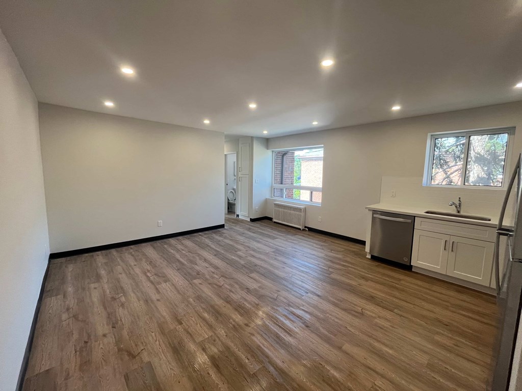 A room with wooden flooring and white walls.