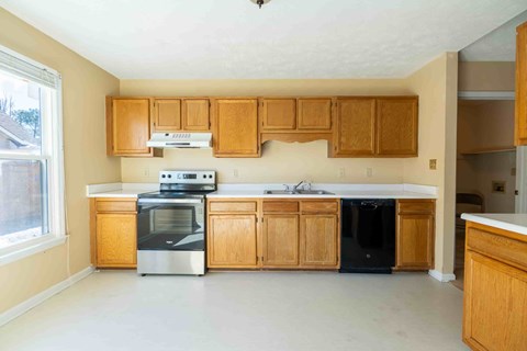 A kitchen with wooden cabinets and a stainless steel oven.