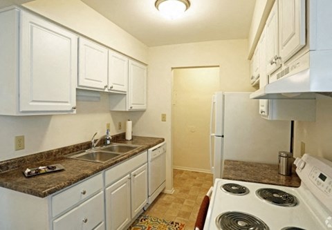 A kitchen with white cabinets and a granite countertop.