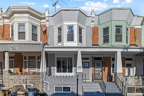 A row of houses with different colored fronts.