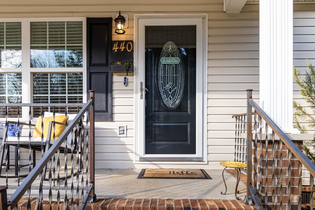 A black door with a glass window and a number 440 on the wall above it.