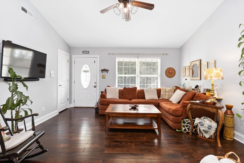 A living room with a brown couch and a wooden coffee table.