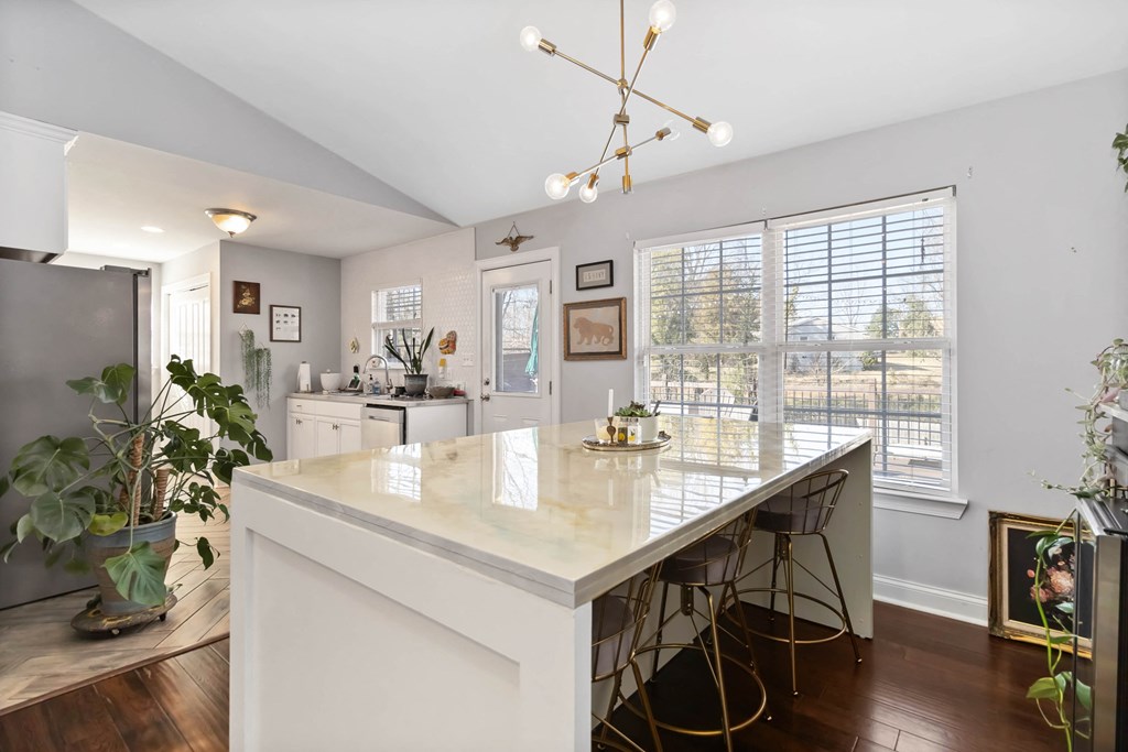 A kitchen with a white island and bar stools.