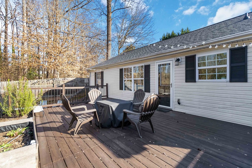 A white house with a deck and chairs.